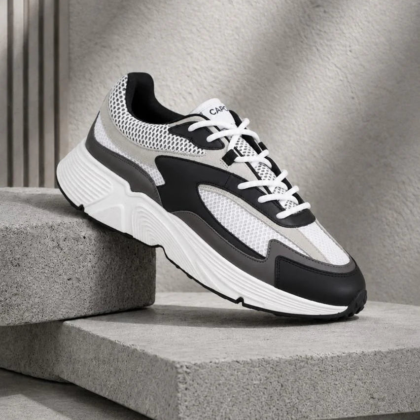 Black and white sneaker on a concrete surface with a neutral background